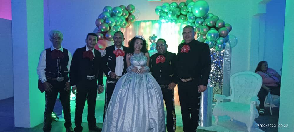 Mariachi en una fiesta de quince años con la quinceañera de vestido plateado
