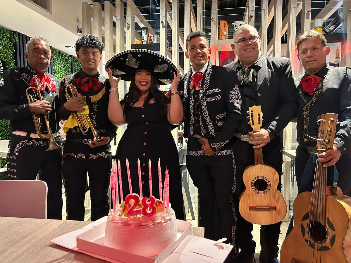 Serenata de cumpleaños número 28 con el mariachi en traje de charro negro y torta