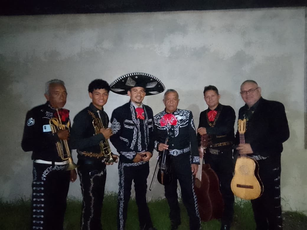 Los músicos del Mariachi Azteca de Acarigua con traje de charro negro, trompetas, violín, guitarrón y vihuela