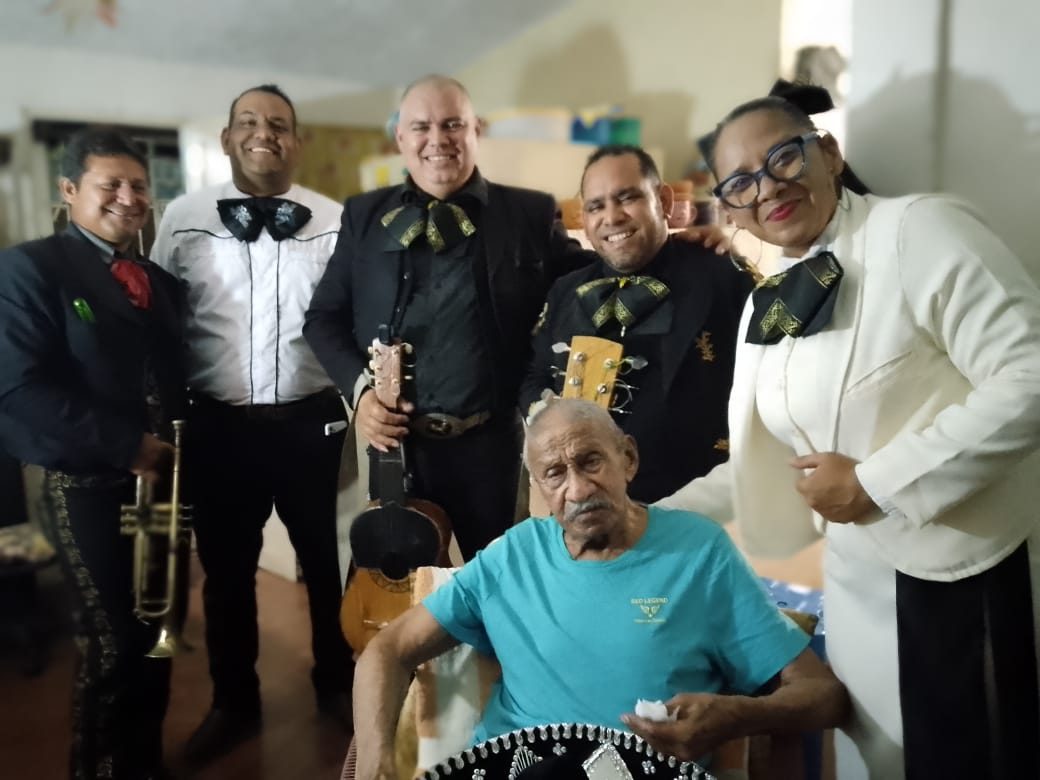 El mariachi junto a un abuelo homenajeado en su casa