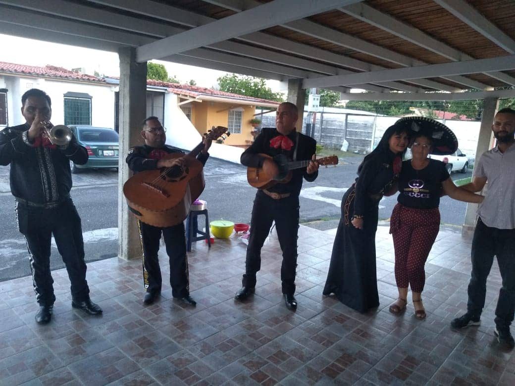 Serenata con mariachi tocando bajo el porche de una casa